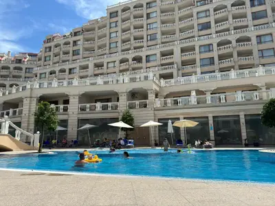a hotel swimming pool in front of a large building at South Bay Luxury Apartment in Varna City