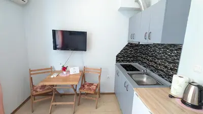 a small kitchen with a small table and a kitchenette with a sink at Studio in the Center of Sunny Beach by Flat Mаnаger in Sunny Beach