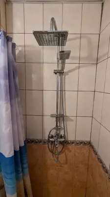 a shower with a shower head on a tiled wall at Studio in the Center of Sunny Beach by Flat Mаnаger in Sunny Beach
