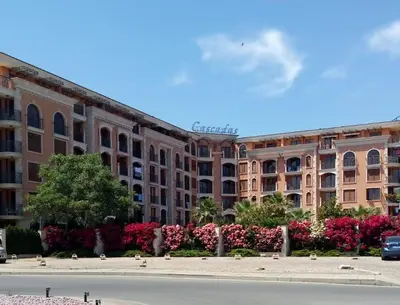 a large building with pink flowers in front of it at Cascadas Victory Suite Ravda in Ravda