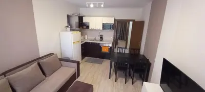 a living room with a couch and a table and a kitchen at Cascadas Victory Suite Ravda in Ravda