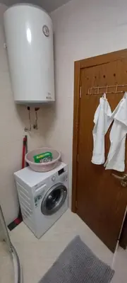 a bathroom with a washing machine and a cabinet at Cascadas Victory Suite Ravda in Ravda