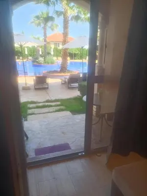a door to a patio with a view of a pool at Cascadas Victory Suite Ravda in Ravda