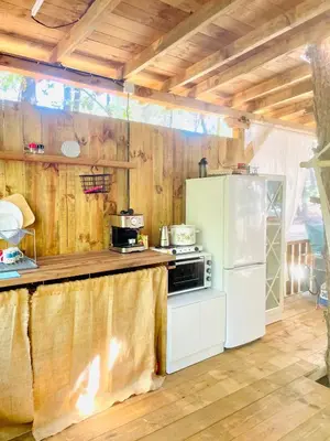 a kitchen with wooden walls and a white refrigerator at Каравана Безвремие in Chernomorets