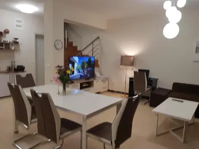 a living room with a table and chairs and a television at Bogdanov in Lozenets