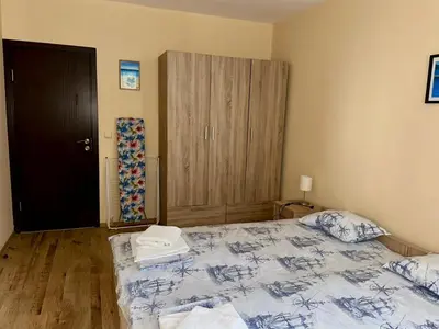 a bedroom with a bed and a wooden floor at Sozopol Dreams - Apartment 1 in Sozopol