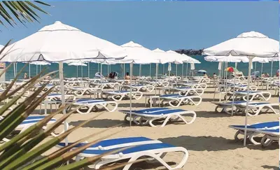 a bunch of chairs and umbrellas on a beach at Rose Village Private Apartment in Sunny Beach