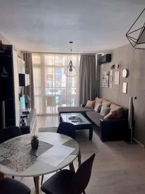 a living room with a couch and a table at Апартамент за нощувки в ЕЛИТ 4 Слънчев бряг in Sunny Beach