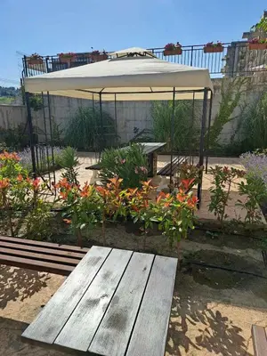 a picnic table and an umbrella in a garden at Sun Holidays Byala in Byala