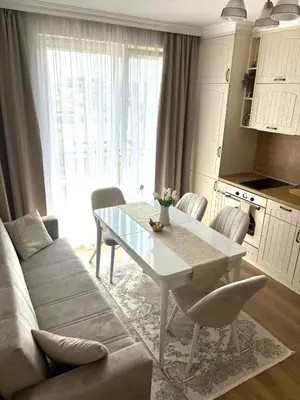 a living room with a table and a couch at Triumph apartment in Burgas City