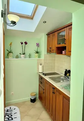 a kitchen with a sink and wooden cabinets and a window at Apartment Anastasia Santa Marina in Sozopol