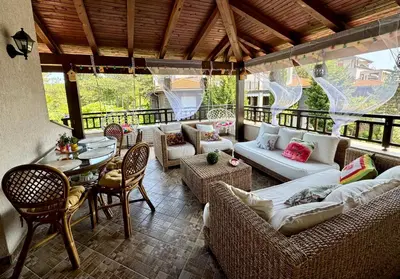 a screened in porch with couches and a table and chairs at Apartment Anastasia Santa Marina in Sozopol