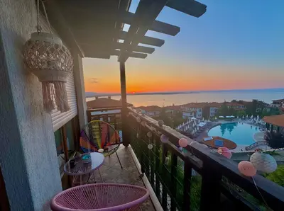 a balcony with tables and chairs and a view of a pool at Apartment Anastasia Santa Marina in Sozopol