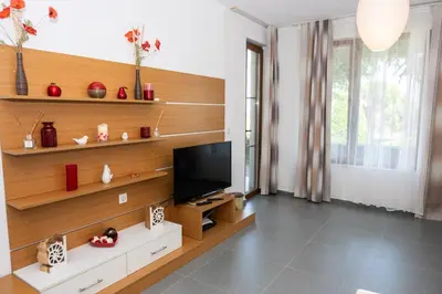 a living room with a flat screen tv on a wooden wall at Apartment in Paradise View complex in Sozopol