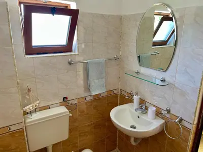 a bathroom with a sink and a mirror and a toilet at Къща за Гости Чайка in Byala