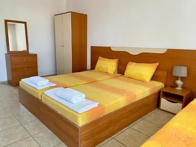 a bedroom with a large wooden bed with two towels at Къща за Гости Чайка in Byala