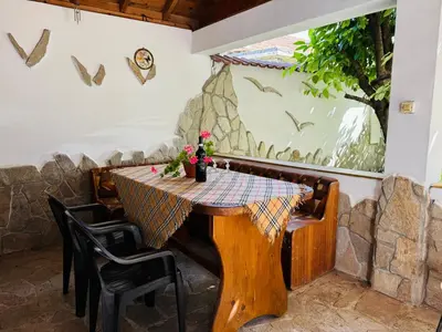 a table in a restaurant with a table and chairs at Къща за Гости Чайка in Byala