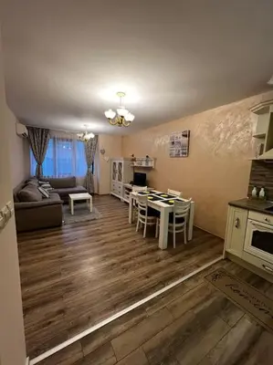 a kitchen and living room with a table and a couch at GREAT Apartament in Burgas City