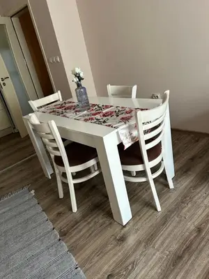 a white table and chairs with a table and flowers on it at GREAT Apartament in Burgas City