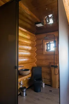 a bathroom with a toilet in a log cabin at Къщи за гости Стара Голица in Golitsa