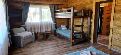 a bedroom with bunk beds in a log cabin at Къщи за гости Стара Голица in Golitsa