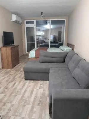 a living room with a couch and a bed at студио Орхидея Сарафово лукс с изглед към морето in Burgas City
