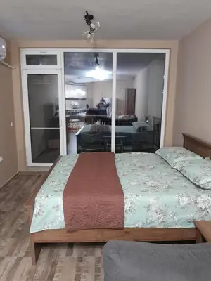 a bedroom with a bed and a large window at студио Орхидея Сарафово лукс с изглед към морето in Burgas City