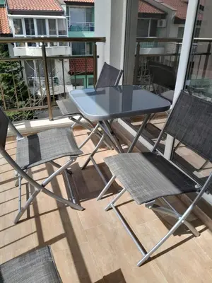 a table and four chairs on a balcony at студио Орхидея Сарафово лукс с изглед към морето in Burgas City