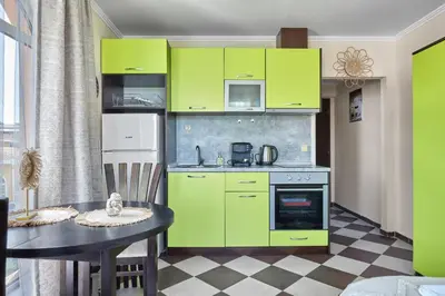 a kitchen with lime green cabinets and a table at Hacienda Beach Studio with Pool by Flat Mаnаger in Sozopol
