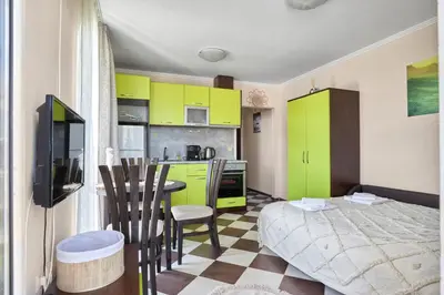 a kitchen with green cabinets and a table in a room at Hacienda Beach Studio with Pool by Flat Mаnаger in Sozopol
