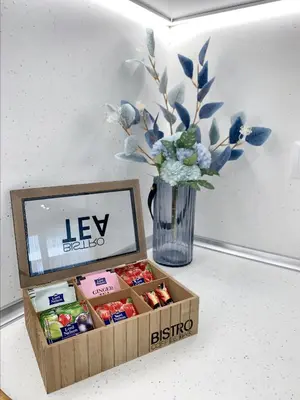 a box of candy on a table next to a vase of flowers at 