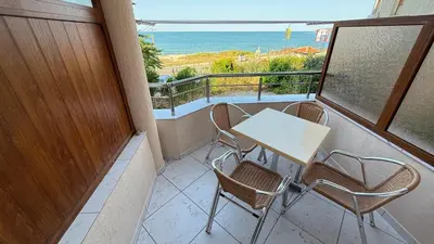 a balcony with a table and chairs and the ocean at Apartment Divna in Sozopol