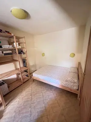 a small room with a bed and a shelf at Apartment Divna in Sozopol