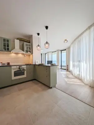 a large kitchen with white walls and a large window at Foros Apartment in Kraymorie