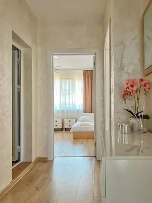 a bedroom with a bed and a vase of flowers in a room at Апартамент Tiana in Tsarevo
