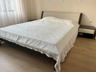 a bedroom with a bed with a white comforter at На гости в Созопол in Sozopol