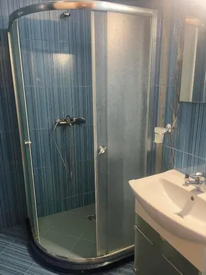 a shower with a glass door next to a sink at На гости в Созопол in Sozopol