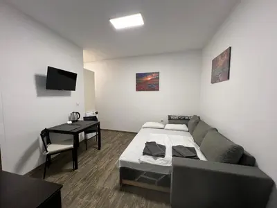 a room with a couch and a desk and a television at Varna Central Sea Studio in Varna City