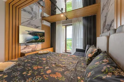 a bedroom with a bed and a large window at Azur Properties ap19 in Shkorpilovtsi