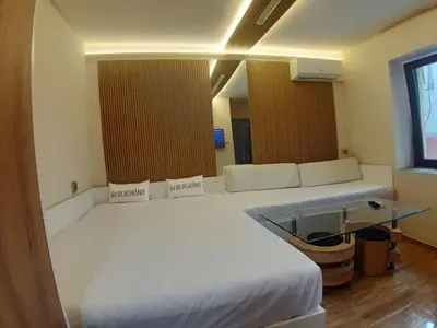 a bedroom with a white bed and a glass table at Apartment TINA in Varna City
