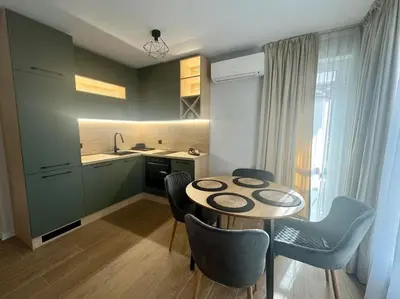 a kitchen with a table and chairs in a room at South Beach Apartment Primorsko in Primorsko