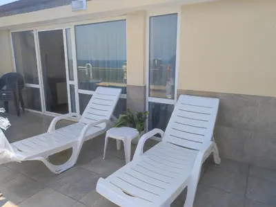 three white chairs sitting on the balcony of a condo at Апартамент с уникална панорама Несебър in Nesebar
