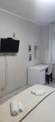 a white room with a bed and a desk at Aпартамент Жужа in Nesebar