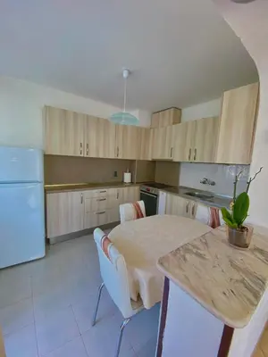 a kitchen with a table and a kitchen with a refrigerator at Guest House Ropotamo in Primorsko
