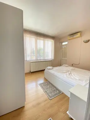 an empty room with a bed and a window at Guest House Ropotamo in Primorsko