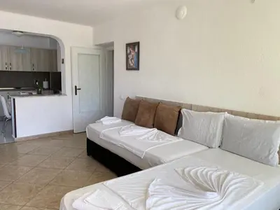 a living room with a couch and a kitchen at Guest House Ropotamo in Primorsko