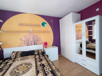 a bedroom with a bed and a purple wall at Riviera Fort Beach Apartment in Ravda