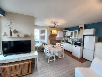 a kitchen and living room with a table and a television at Riviera Fort Beach Apartment in Ravda