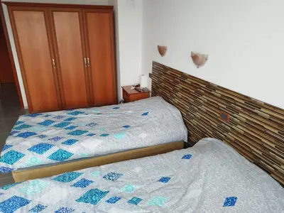a bedroom with two beds and a wooden headboard at California complex in Sunny Beach