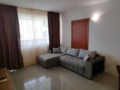 a living room with a couch in front of a window at California complex in Sunny Beach